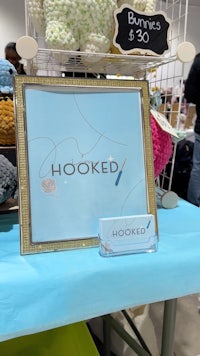 hooked is a framed sign on a table
